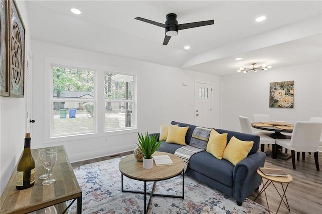 living room with ceiling fan, wood-type flooring, and vaulted ceiling