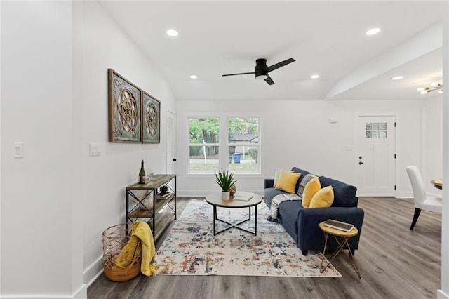 living room with ceiling fan, wood-type flooring, and vaulted ceiling