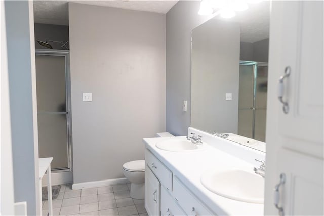 1043 Foxhollow Trl, Canton, GA 30115 - bathroom featuring a shower stall, tile patterned floors, double vanity, toilet, and a textured ceiling