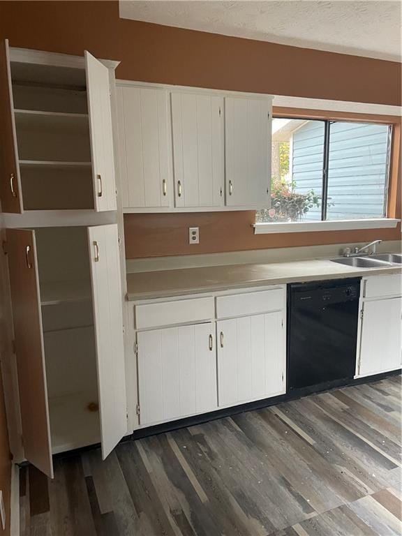 kitchen featuring dark wood-type flooring, white cabinetry, sink, and black dishwasher