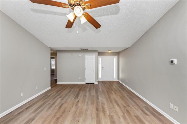 unfurnished living room with light hardwood / wood-style floors and a textured ceiling