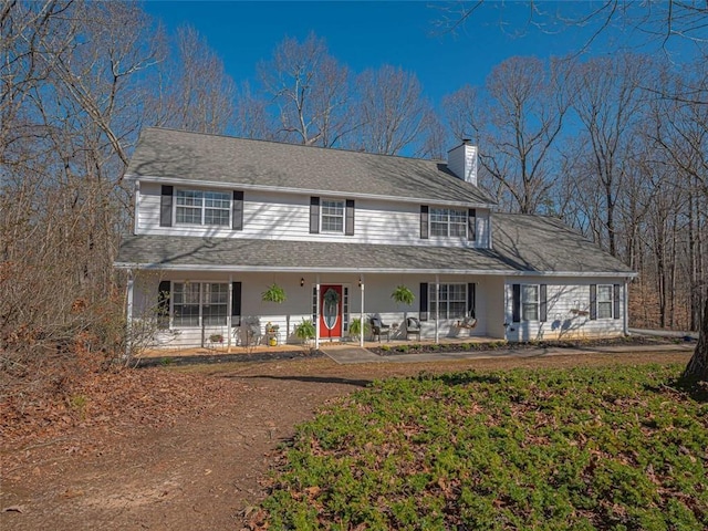 farmhouse inspired home with covered porch and a chimney