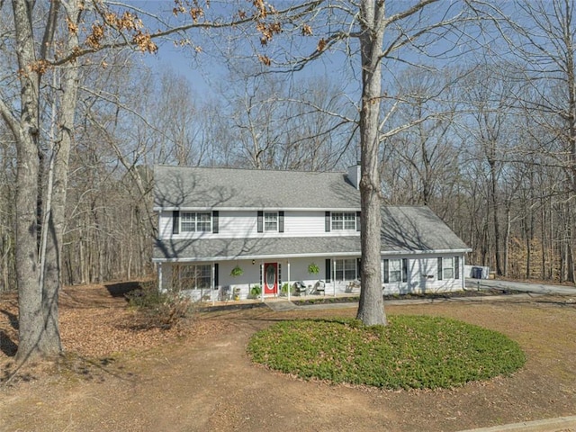 view of front of house with roof with shingles and a chimney