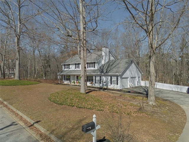 view of front facade featuring fence, concrete driveway, covered porch, a chimney, and an attached garage