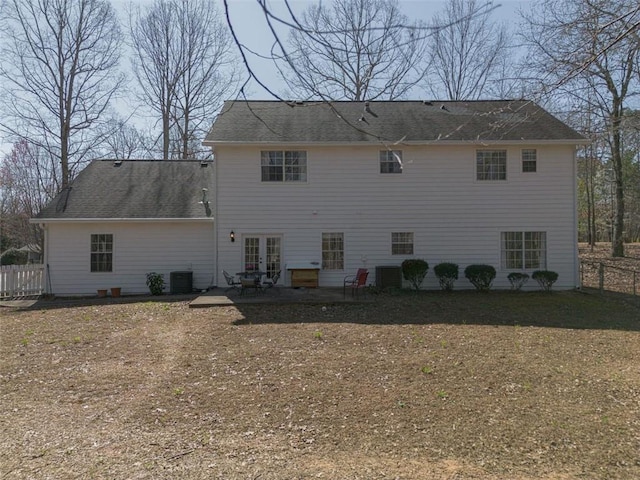 rear view of house with cooling unit, fence, a shingled roof, french doors, and a patio area