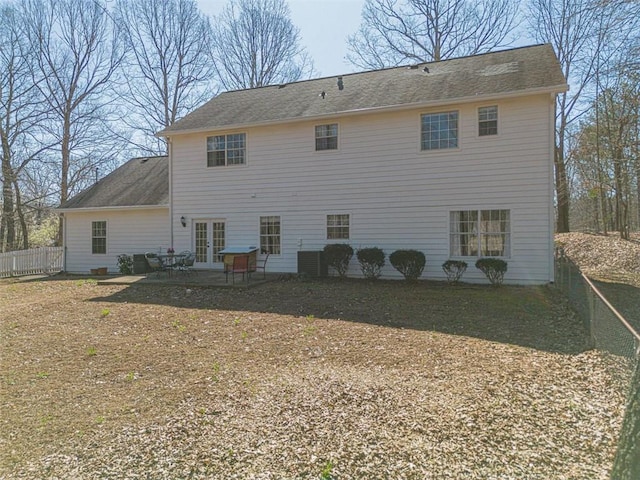 back of property featuring french doors, roof with shingles, a patio, and fence