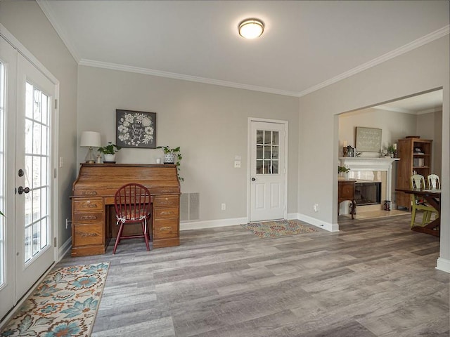 foyer with wood finished floors, baseboards, visible vents, a fireplace, and crown molding