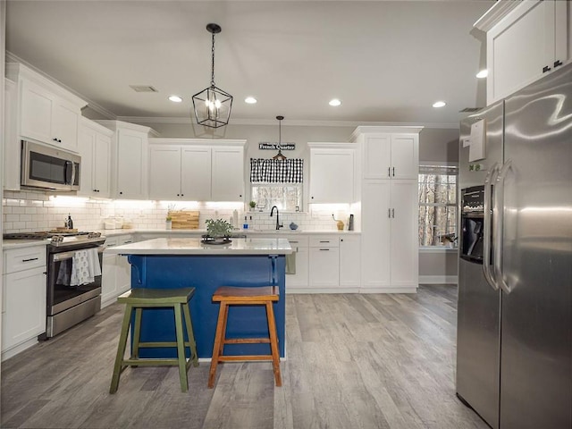 kitchen with white cabinets, stainless steel appliances, light countertops, and a sink