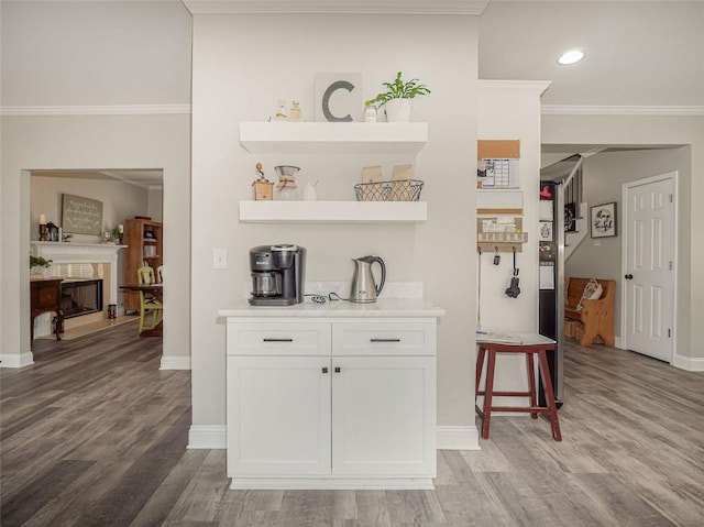 bar with baseboards, crown molding, and light wood-style floors