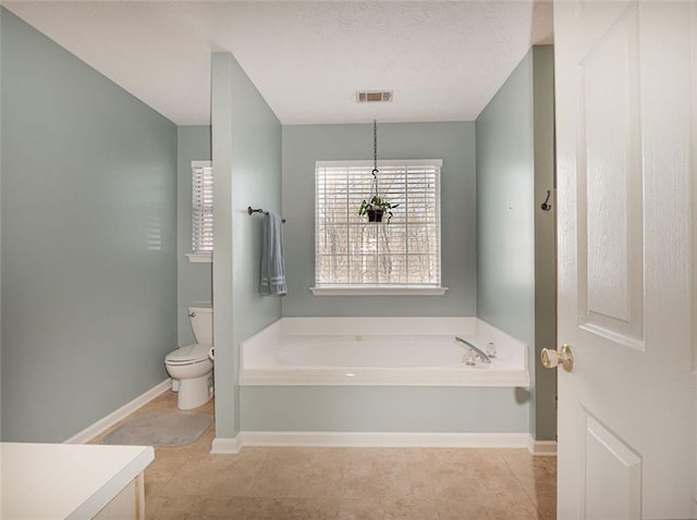 full bathroom featuring baseboards, toilet, a bath, and tile patterned flooring