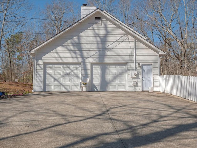 detached garage featuring fence