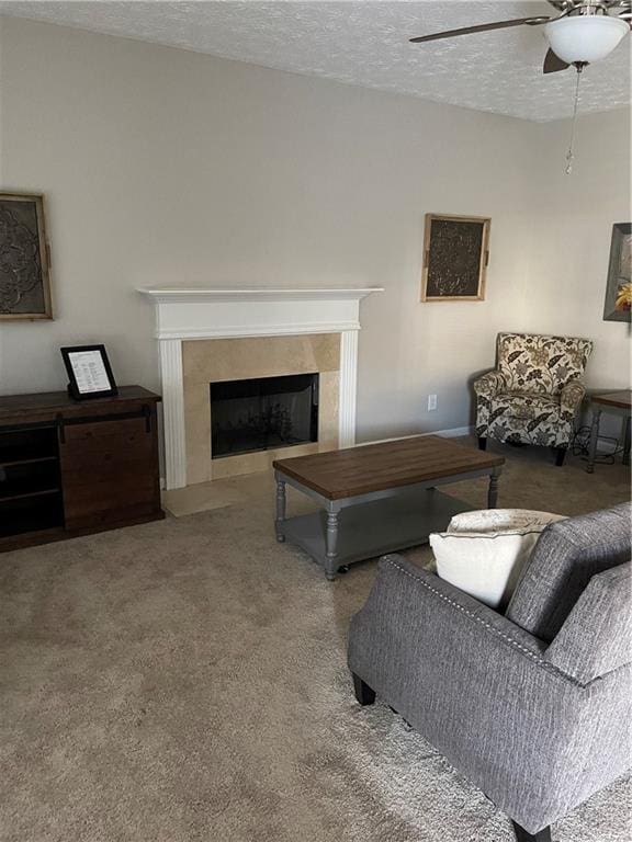 living room with carpet flooring, a premium fireplace, ceiling fan, and a textured ceiling