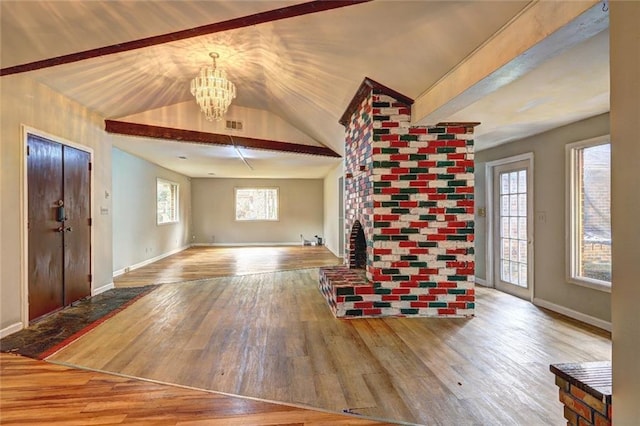 unfurnished living room with hardwood / wood-style flooring, a notable chandelier, and lofted ceiling