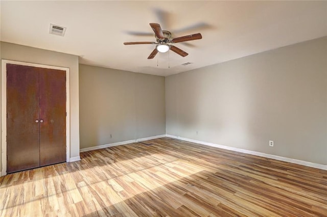 unfurnished bedroom featuring a closet, light hardwood / wood-style floors, and ceiling fan