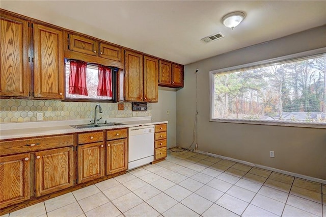 kitchen with decorative backsplash, sink, white dishwasher, and plenty of natural light