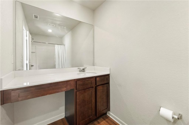 bathroom featuring a shower with shower curtain, vanity, and hardwood / wood-style flooring