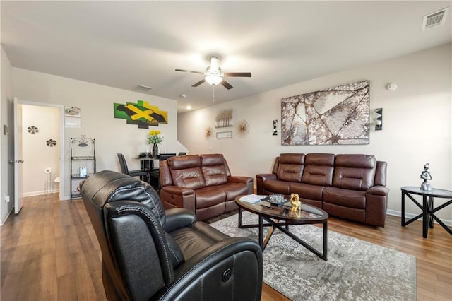 living room featuring ceiling fan and light hardwood / wood-style floors