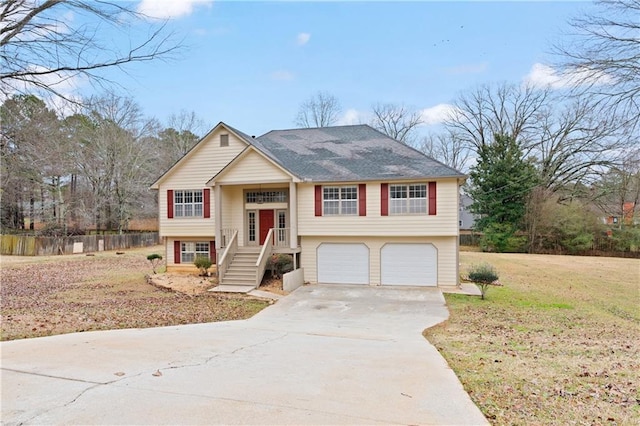 raised ranch featuring a garage and a front lawn