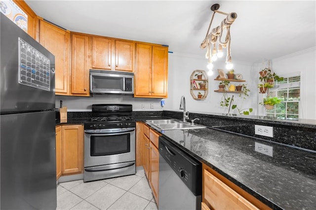 kitchen featuring sink, hanging light fixtures, dark stone counters, appliances with stainless steel finishes, and ornamental molding