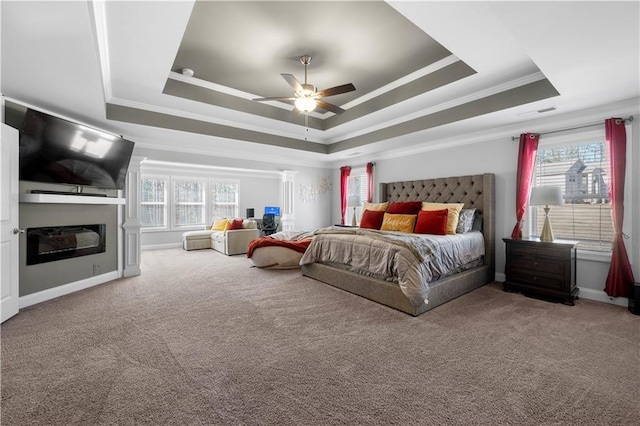 bedroom featuring crown molding, carpet floors, a raised ceiling, and ceiling fan