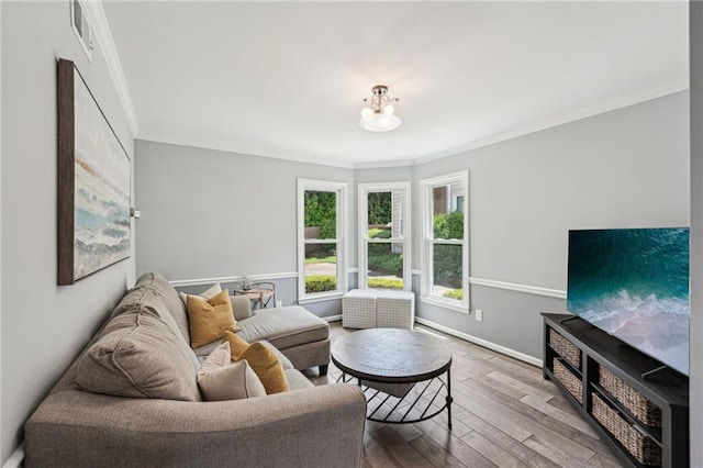 living area with crown molding, wood finished floors, and baseboards