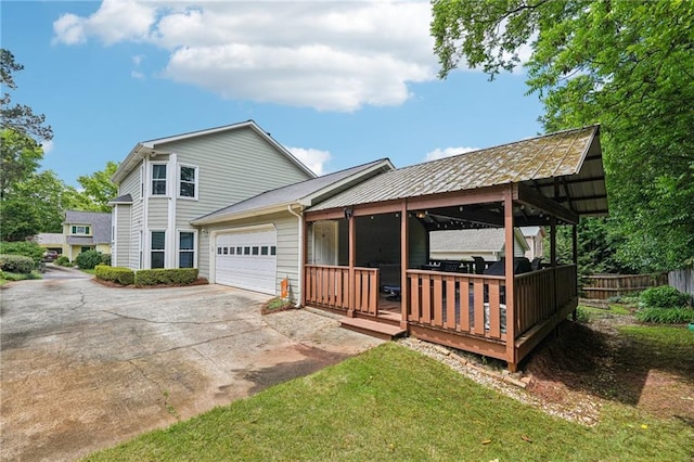 back of house with a garage, driveway, and fence