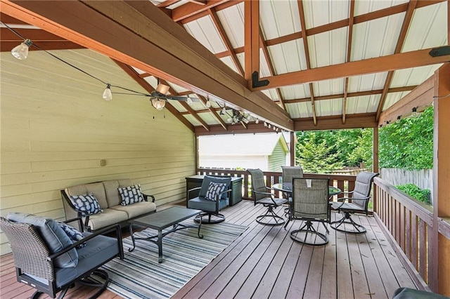 wooden deck with outdoor dining area, outdoor lounge area, ceiling fan, and fence