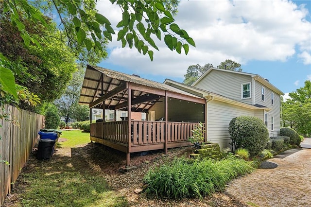 back of house featuring a deck and fence