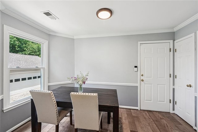 dining space featuring ornamental molding, wood finished floors, and baseboards