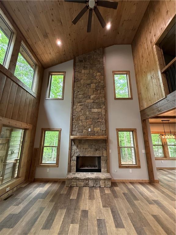 34 Cherry Ct, Ellijay, GA 30540 - unfurnished living room with high vaulted ceiling, wood ceiling, wood finished floors, ceiling fan, and a stone fireplace