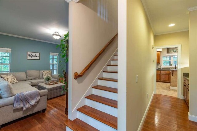 staircase featuring hardwood / wood-style flooring, plenty of natural light, and crown molding