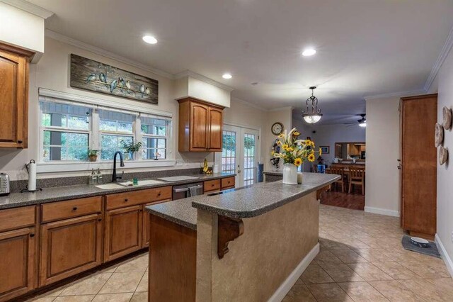 kitchen with ornamental molding, ceiling fan, a center island, and sink