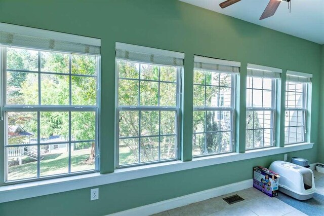 interior space with light tile patterned flooring, ceiling fan, and a wealth of natural light