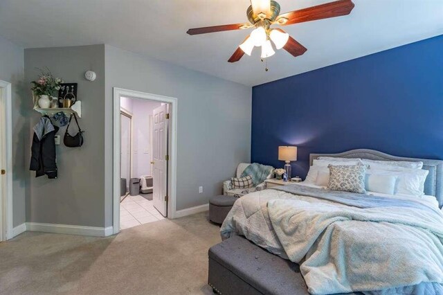 bedroom with light carpet, connected bathroom, and ceiling fan