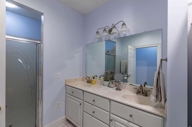 bathroom with tile patterned floors, walk in shower, and vanity