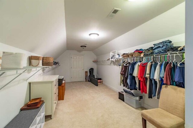 spacious closet featuring lofted ceiling and light colored carpet