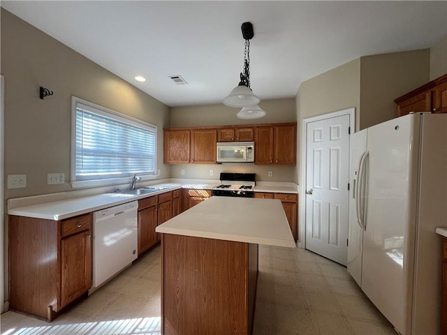 kitchen featuring sink, white appliances, decorative light fixtures, and a center island