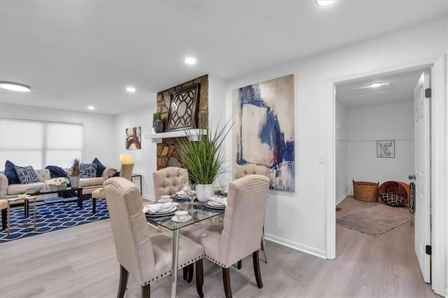 dining space with wood finished floors, baseboards, and recessed lighting