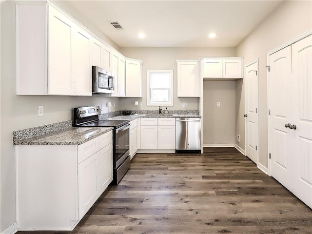 kitchen featuring light stone countertops, dark wood-type flooring, white cabinets, and stainless steel appliances