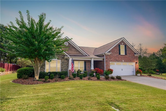 craftsman inspired home with a garage, concrete driveway, stone siding, a front lawn, and brick siding