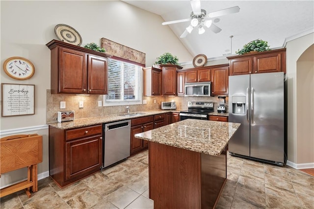 kitchen with arched walkways, appliances with stainless steel finishes, light stone counters, and decorative backsplash