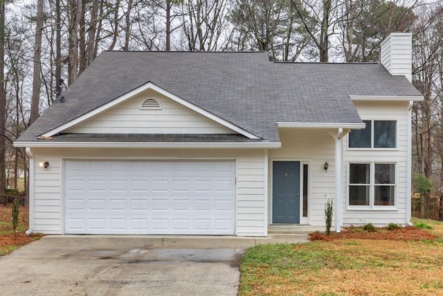 view of front of home featuring driveway, a shingled roof, a chimney, and an attached garage