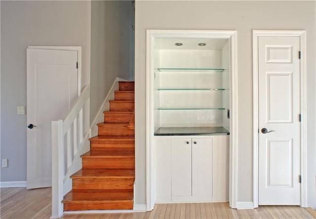 staircase with baseboards and wood finished floors