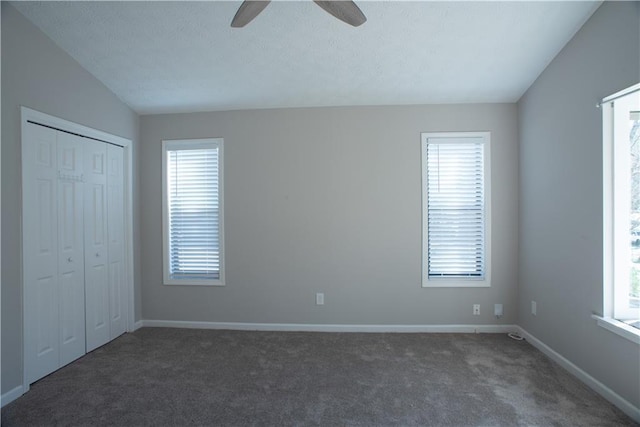 unfurnished bedroom with baseboards, multiple windows, and carpet flooring