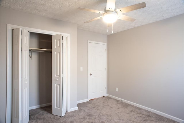 unfurnished bedroom with carpet floors, baseboards, a ceiling fan, and a closet