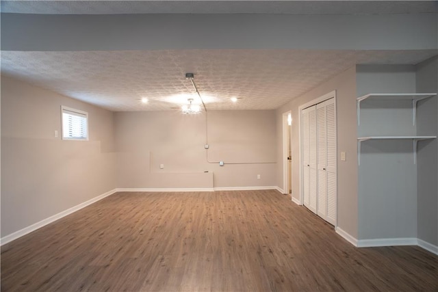 below grade area featuring baseboards and wood finished floors