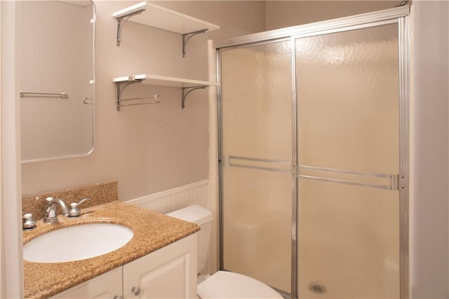 full bath featuring vanity, a stall shower, and toilet