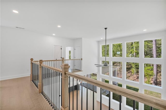 corridor with recessed lighting, visible vents, baseboards, and an upstairs landing