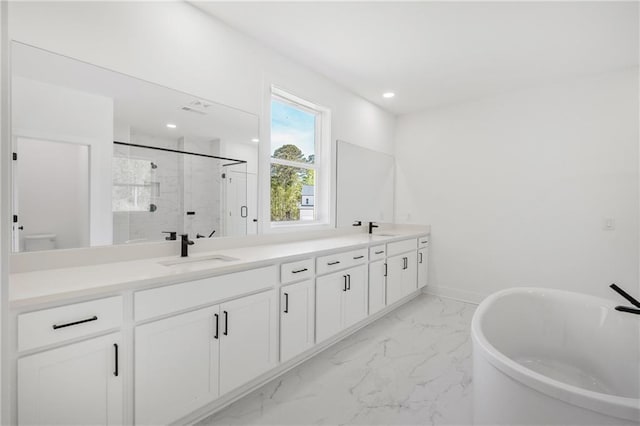 full bath featuring marble finish floor, a marble finish shower, a sink, and double vanity