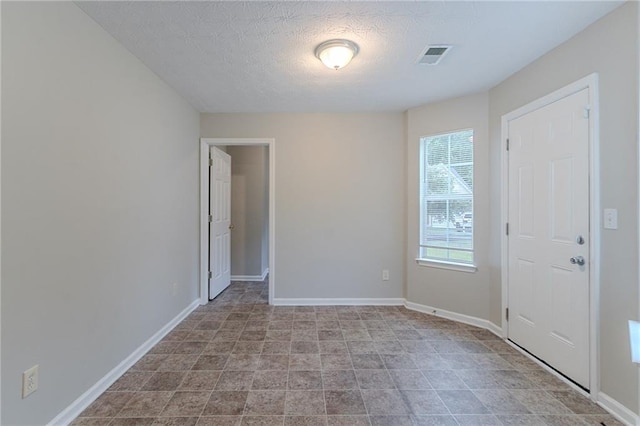 6181 E Fayetteville Dr, Riverdale, GA 30296 - empty room featuring a textured ceiling and stone finish floors